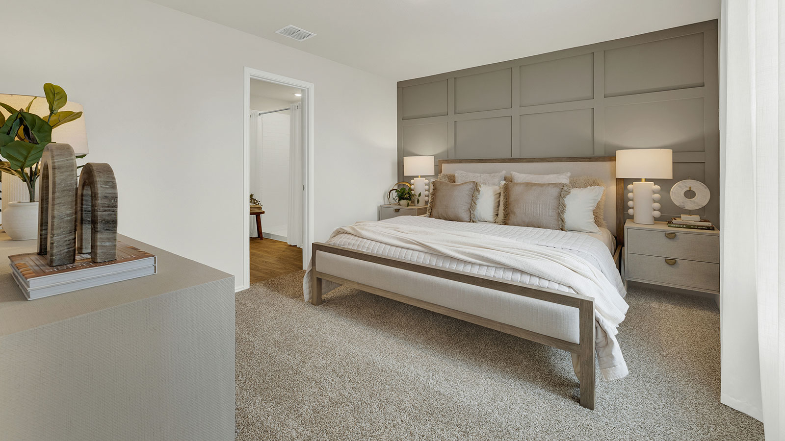 Main bedroom with carpeting and windows.