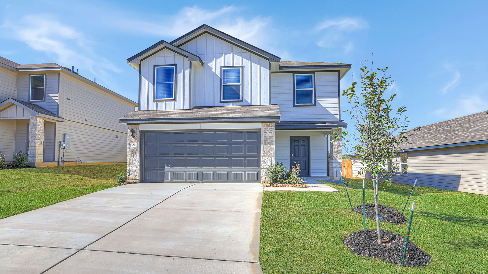 Two-story farmhouse exterior photo with 2 car garage.
