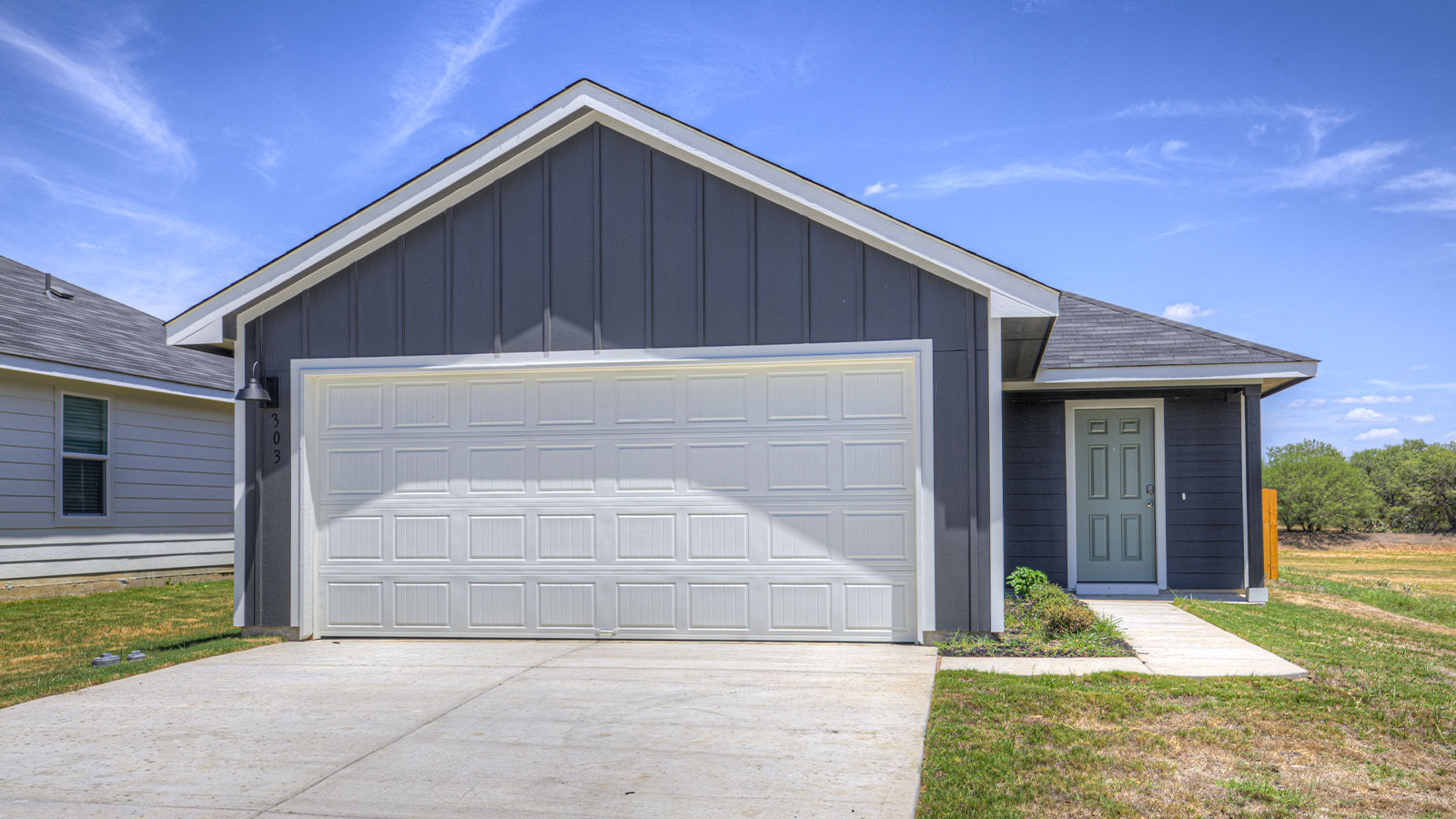 Single-story farmhouse with 2 car garage.