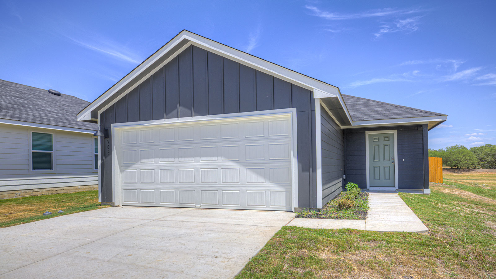 Single-story farmhouse with 2 car garage.