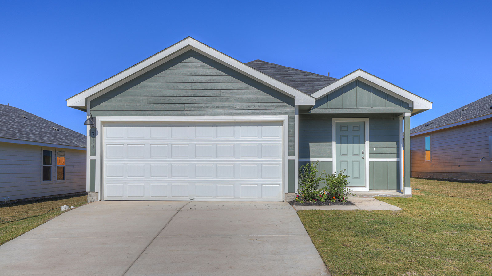 Single-story farmhouse with 2 car garage.