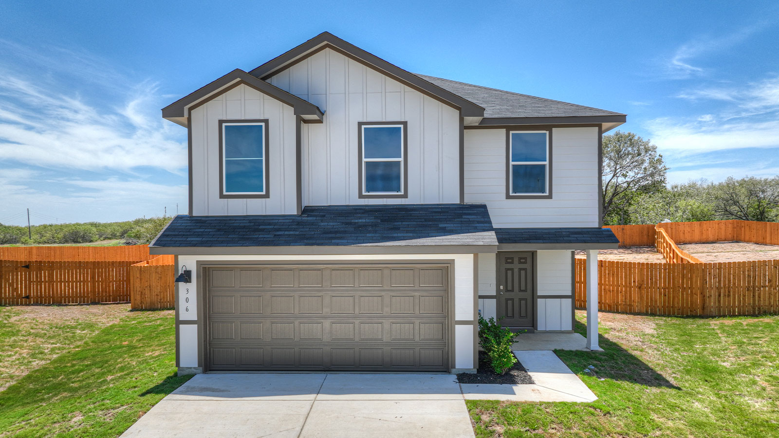Two-story farmhouse exterior with 2 car garage.