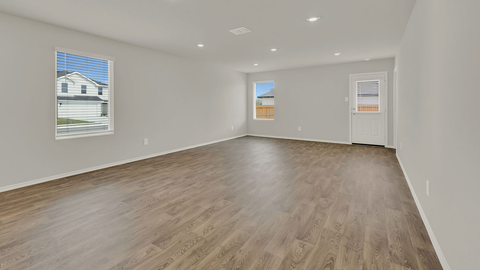 Dining room and living room with vinyl flooring, with windows, and a half lite exterior door.