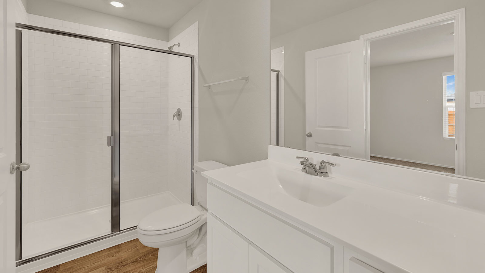 Main bathroom with vanity, toilet, and walk-in shower.