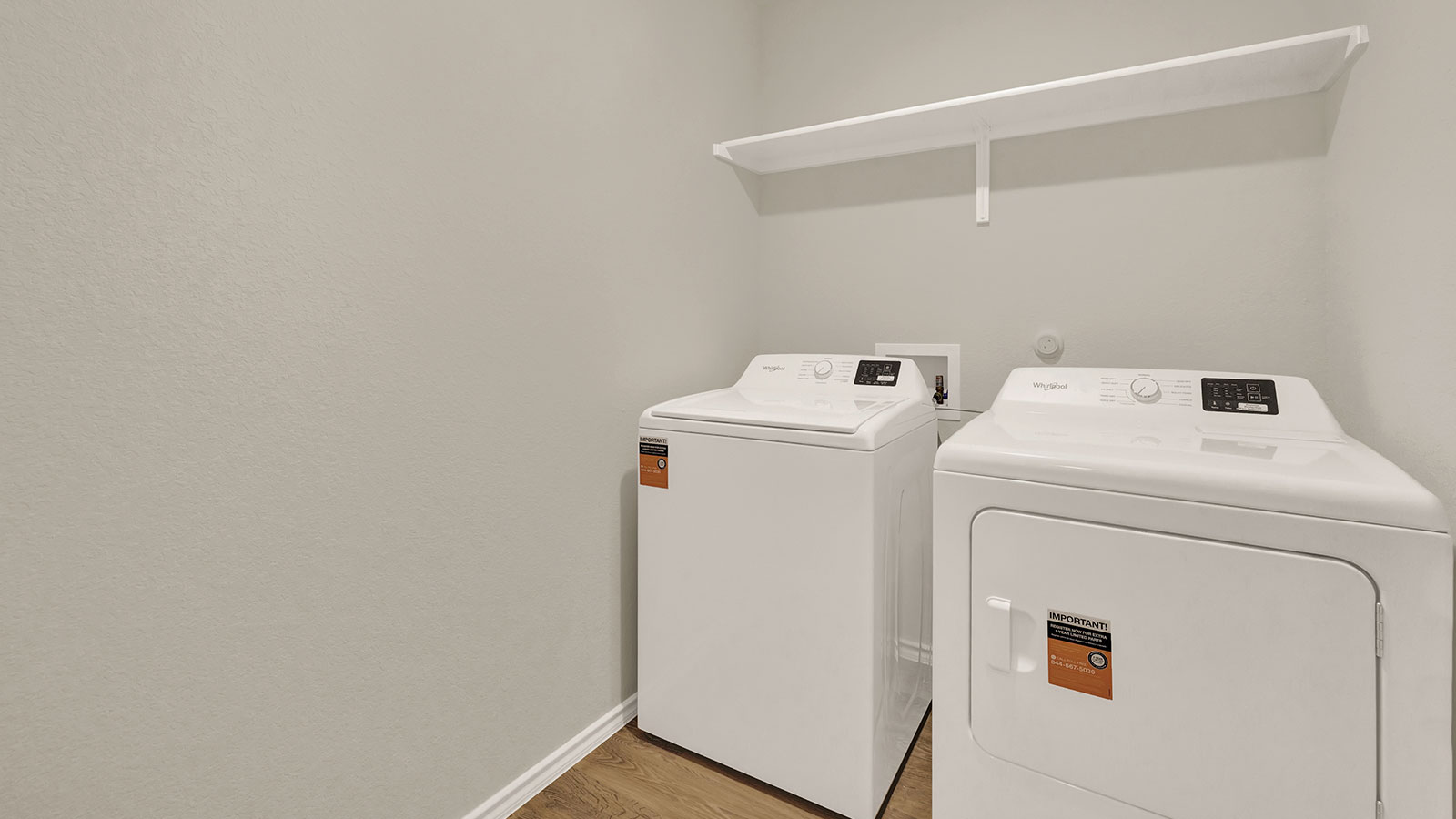 Utility room with washer/dryer connections and wooden shelving.