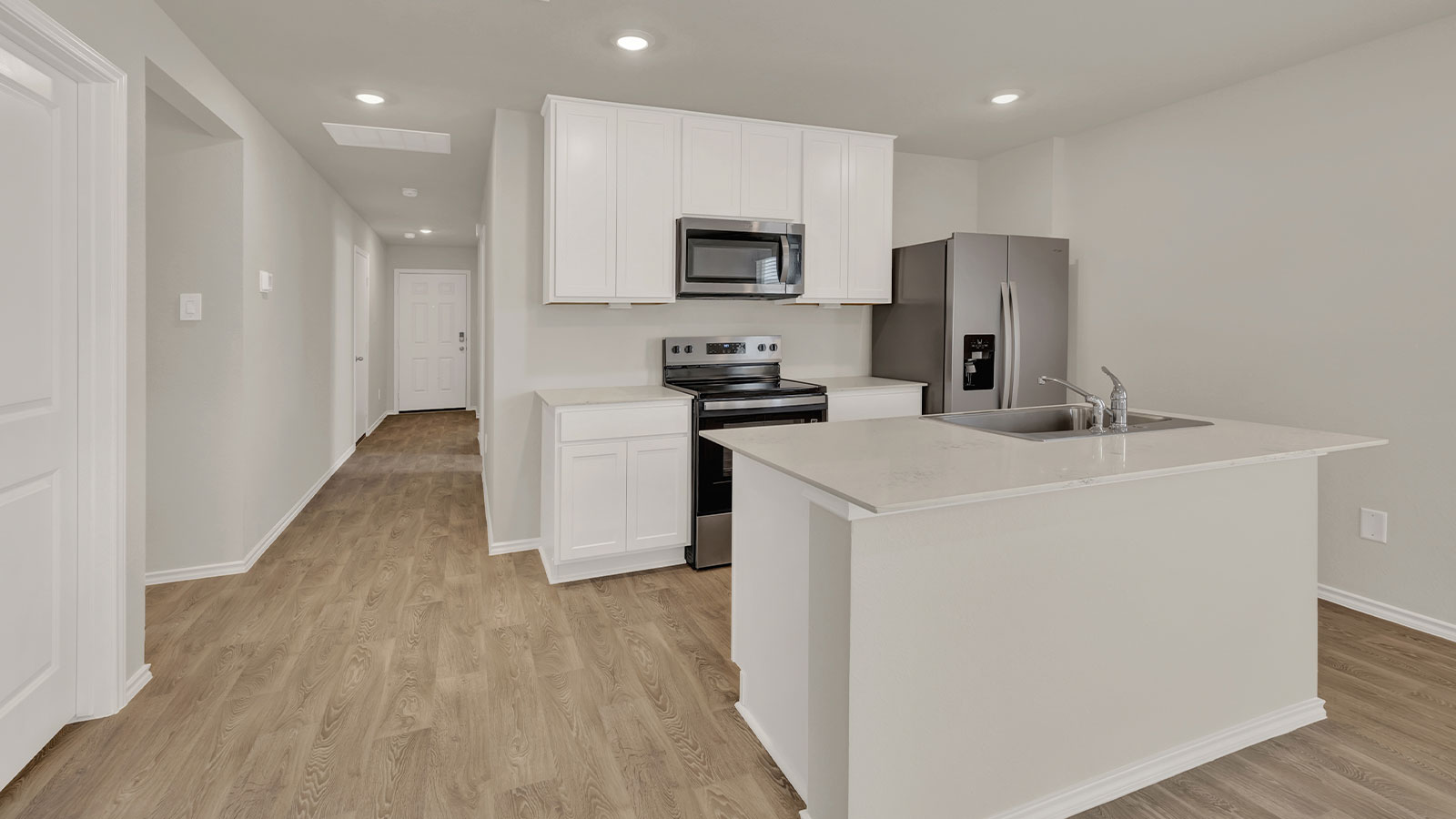 Entry hallway leading to the kitchen with kitchen island.