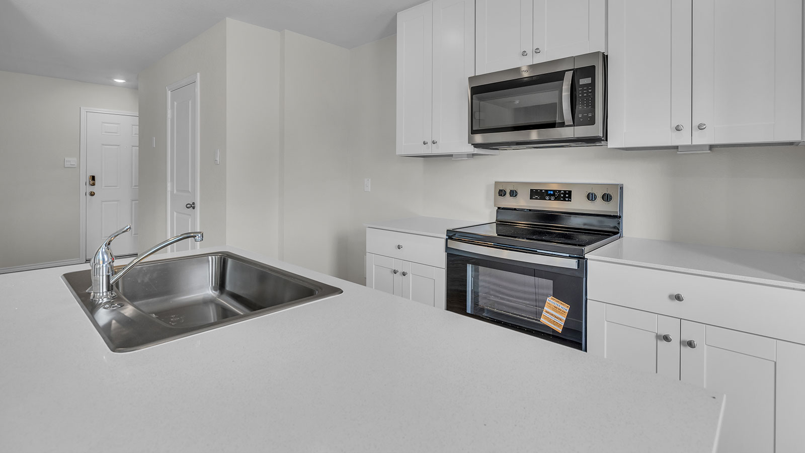 Kitchen island with quartz countertops and stainless steel sink.