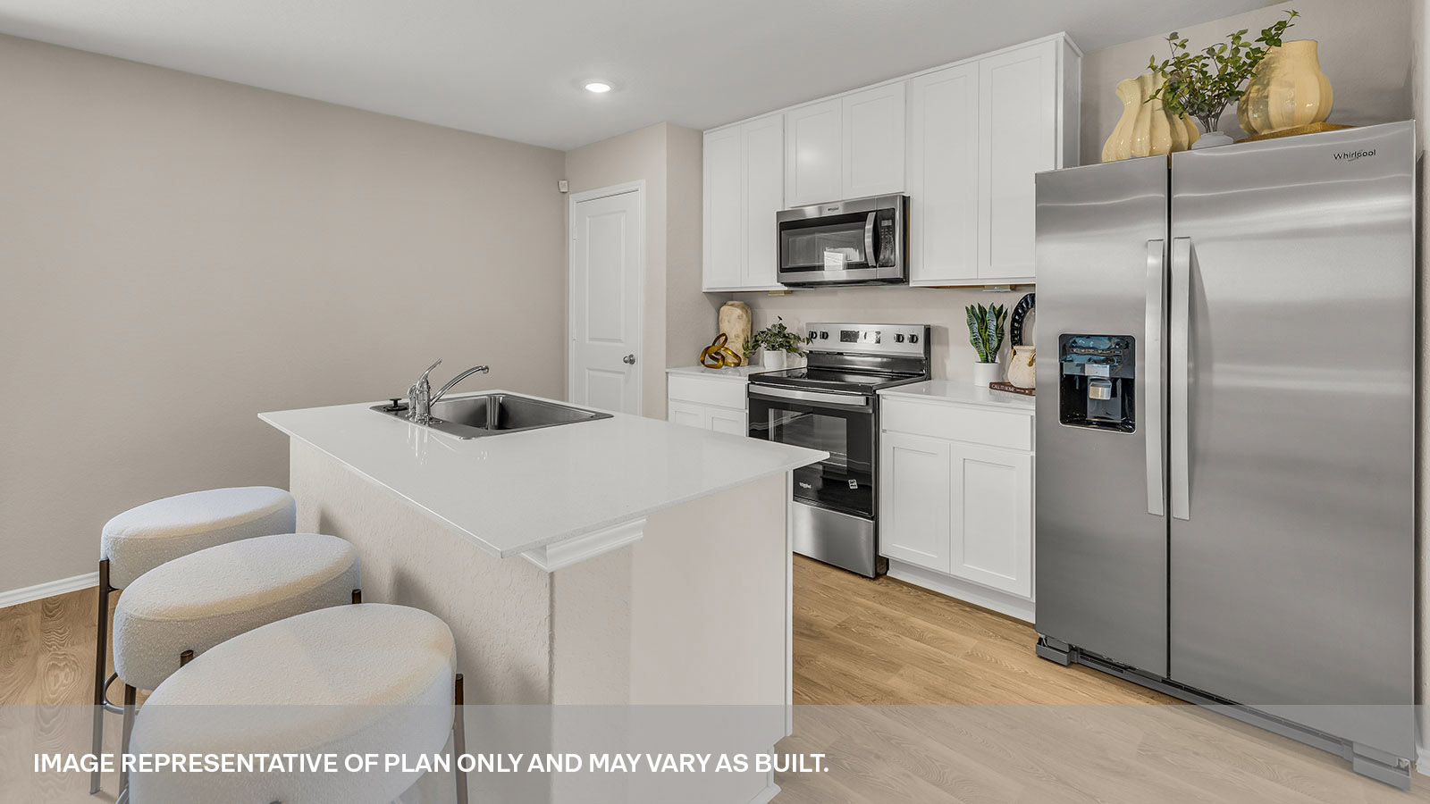 Kitchen island with quartz countertops and stainless steel appliances.