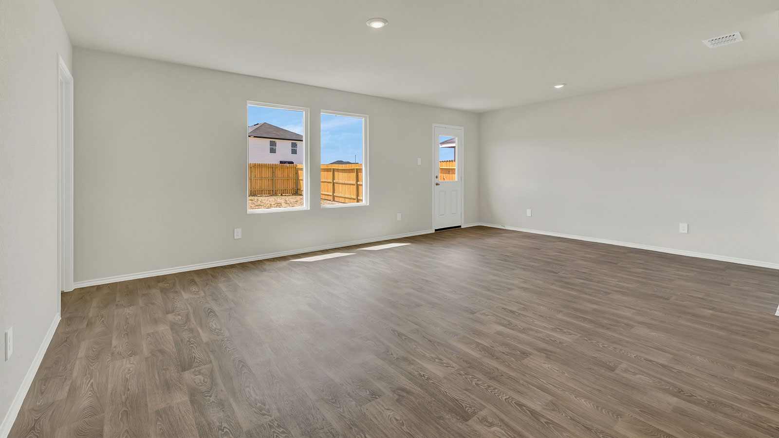 Living room with vinyl flooring opening to the dining room.