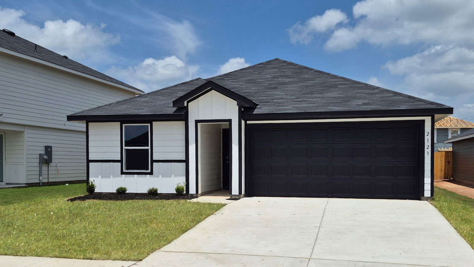 Single-story farmhouse exterior with a 2 car garage.