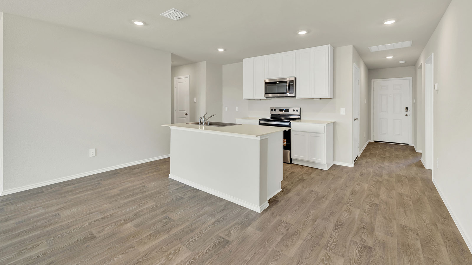 Entry hallway leading to the kitchen with kitchen island.