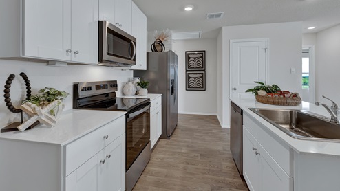 Kitchen with quartz countertops and stainless-steel appliances.
