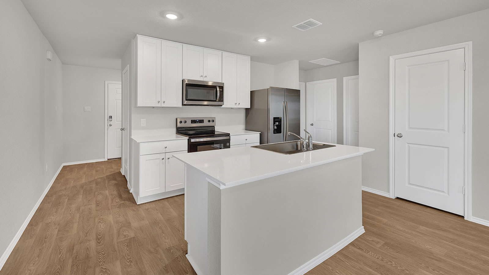 Kitchen with kitchen island and entry hallway.