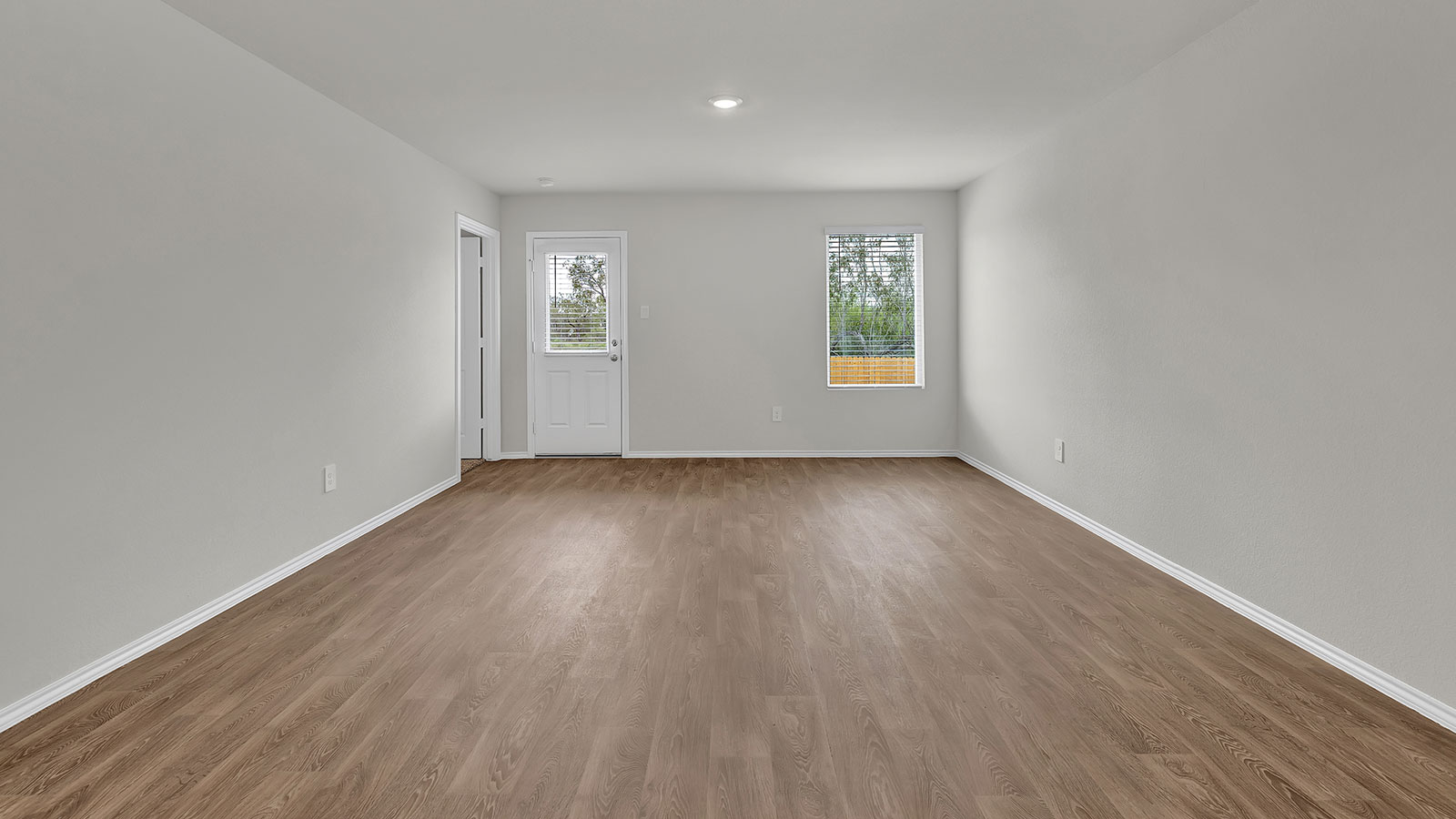 Living room with vinyl flooring, 2 windows, and  half lite exterior door.