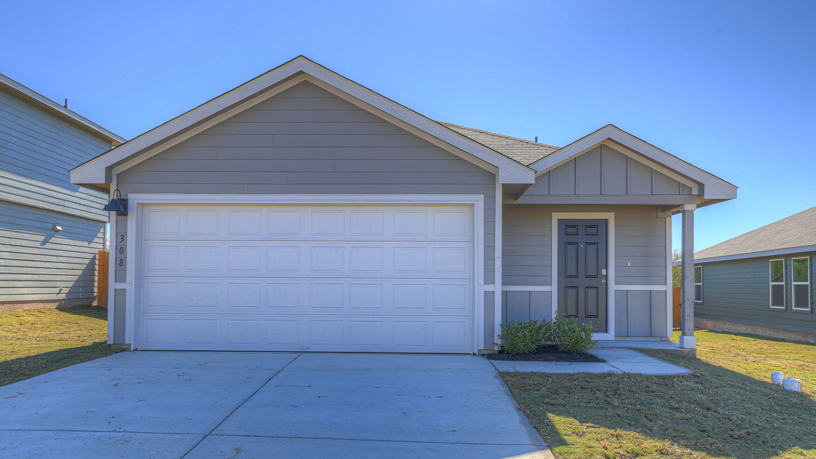 Single-story farmhouse with 2 car garage.