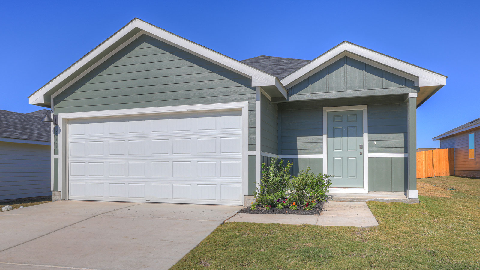 Single-story farmhouse with 2 car garage.