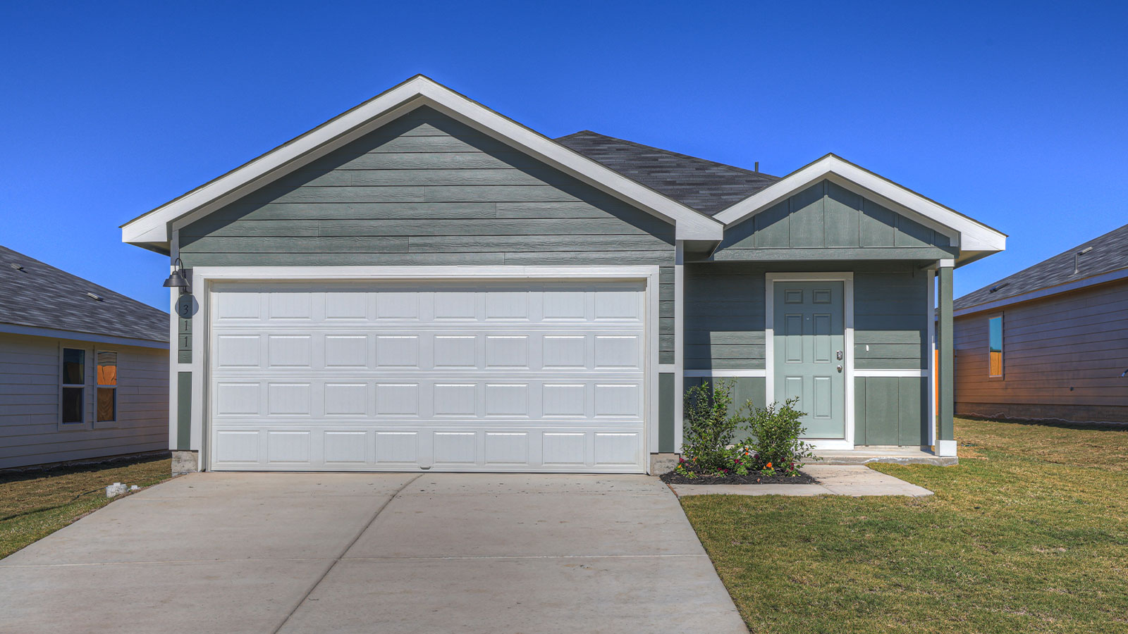 Single-story farmhouse with 2 car garage.
