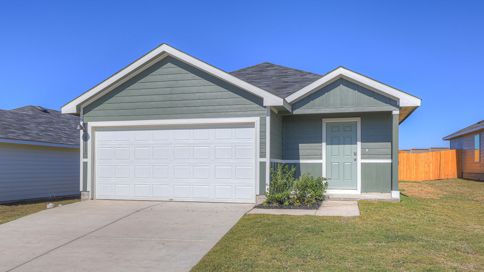 Single-story farmhouse with 2 car garage.