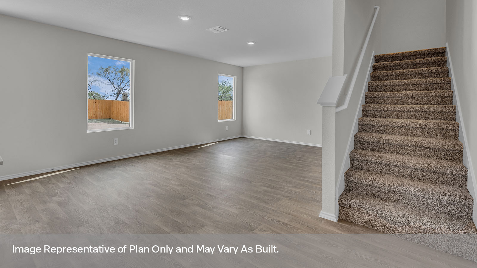 Living and dining room featuring the staircase to the second floor