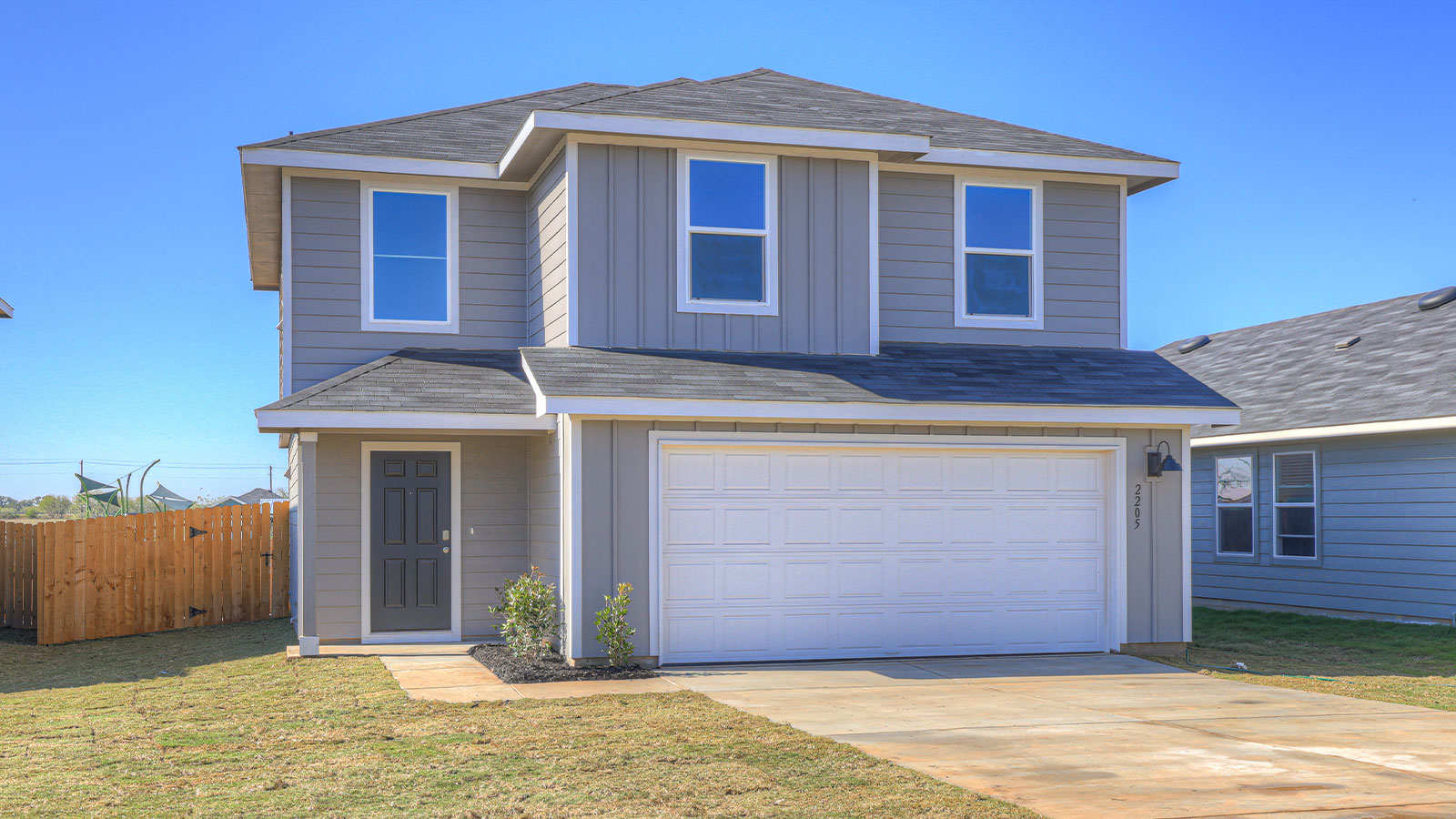 Two-story farmhouse exterior photo with 2 car garage.