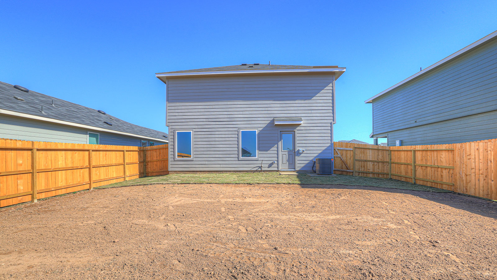 Backyard partially sodded with privacy fence.