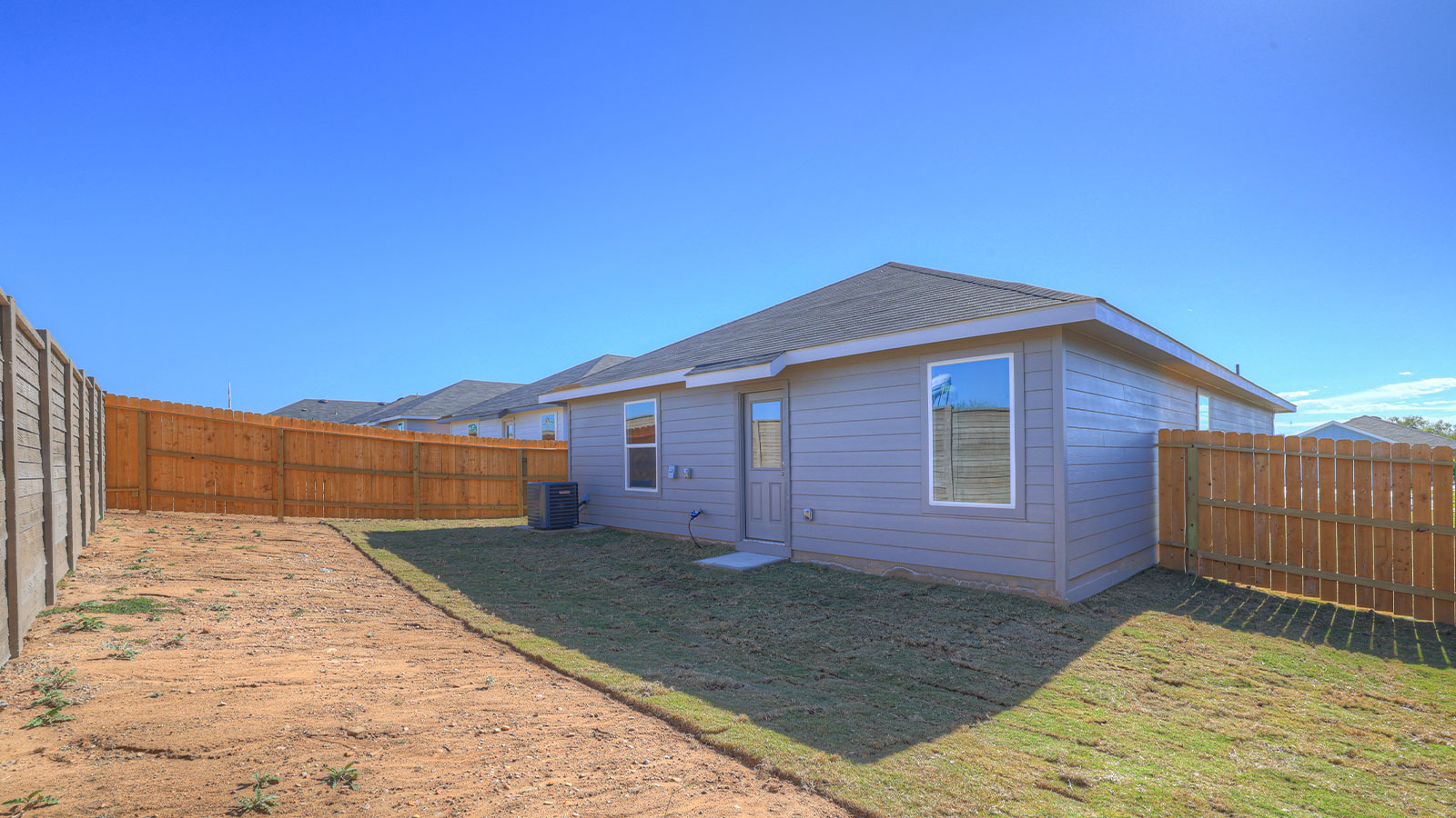 Partially sodded yard with privacy fence
