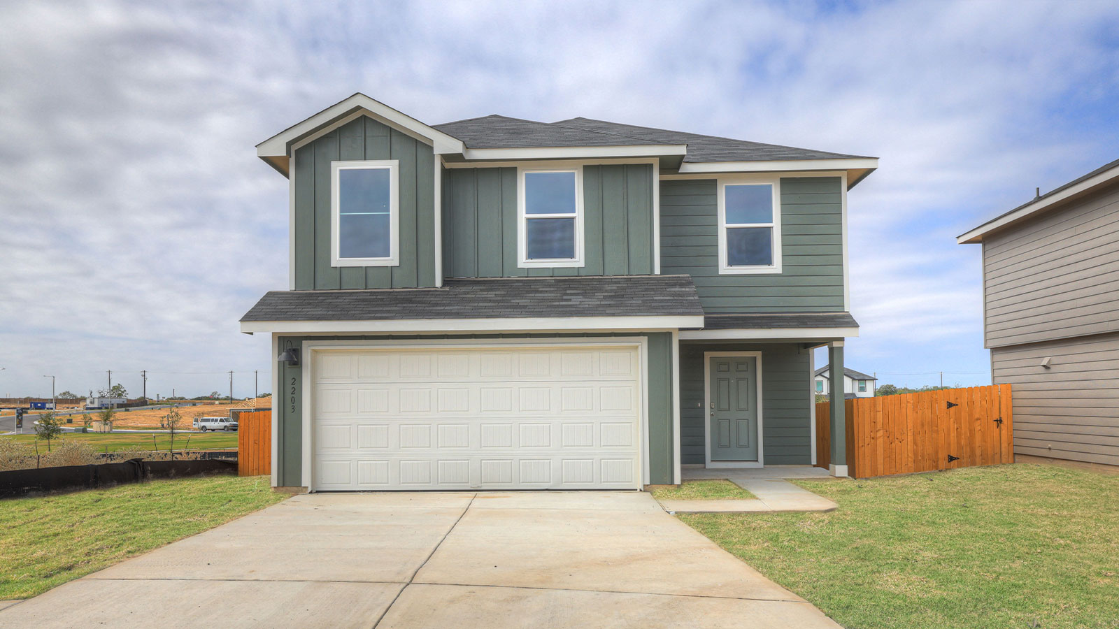 Two-story farmhouse exterior photo with 2 car garage.