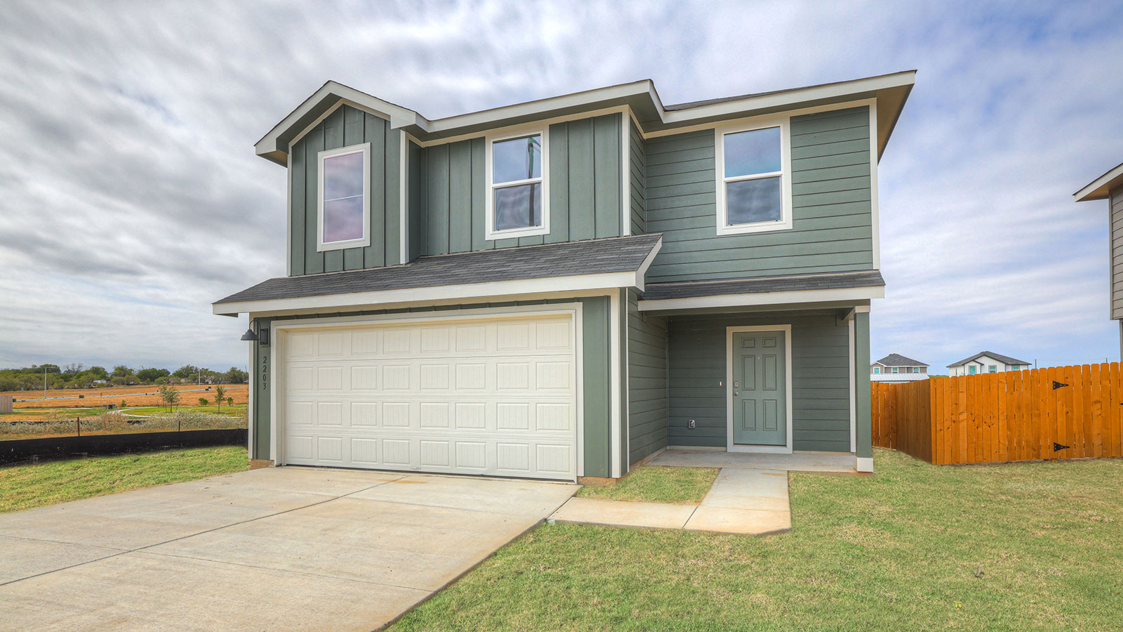 Two-story farmhouse exterior photo with 2 car garage.