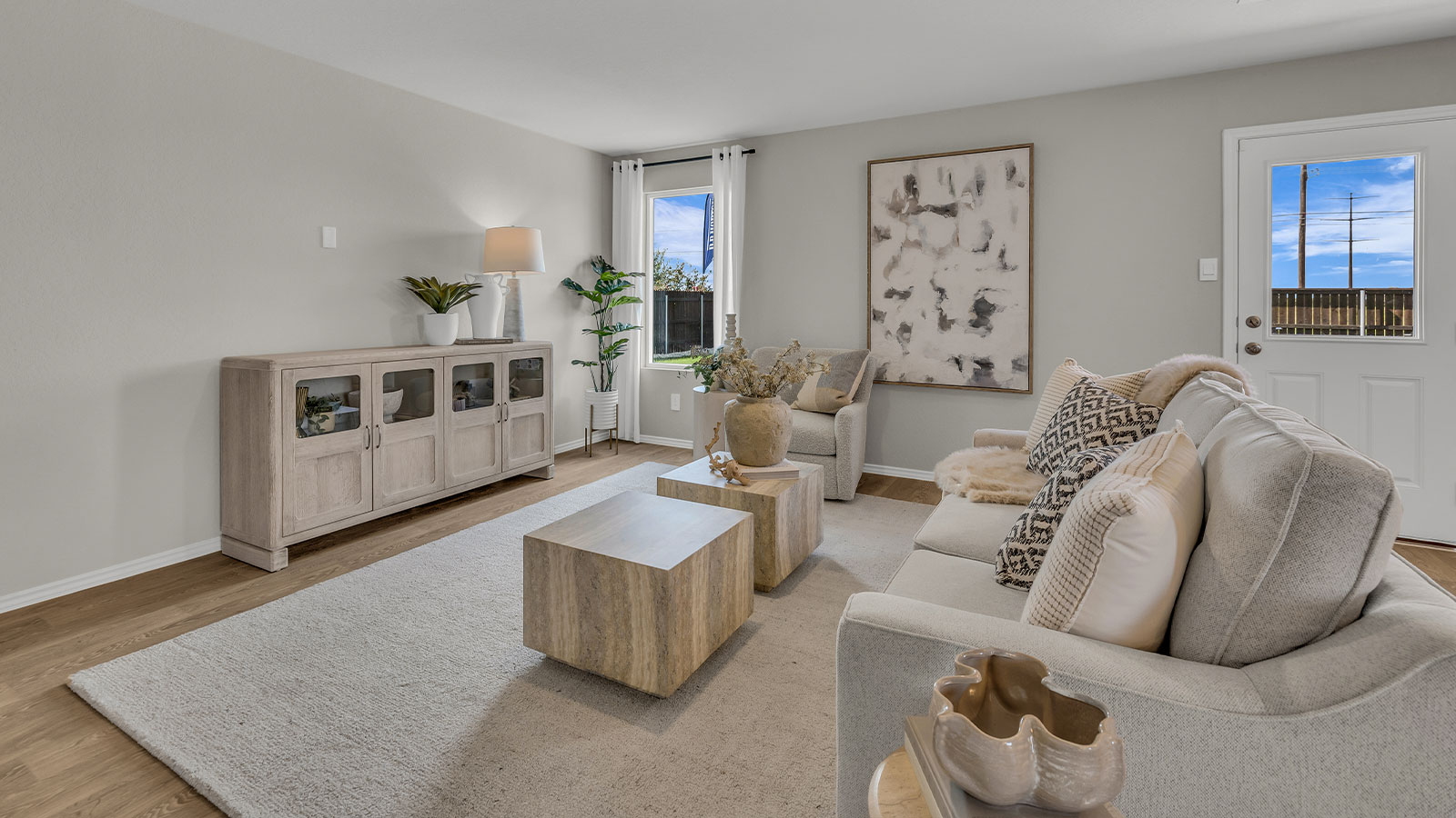 Living room with vinyl flooring, one window, and a half lite exterior door.