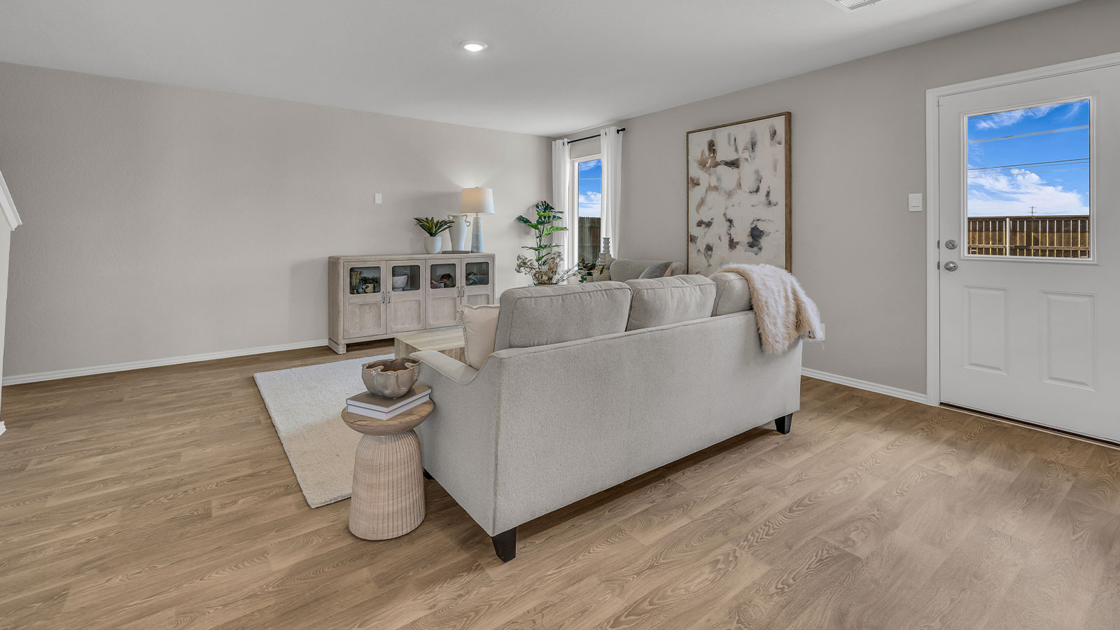 Living room with vinyl flooring, one window, and a half lite exterior door.