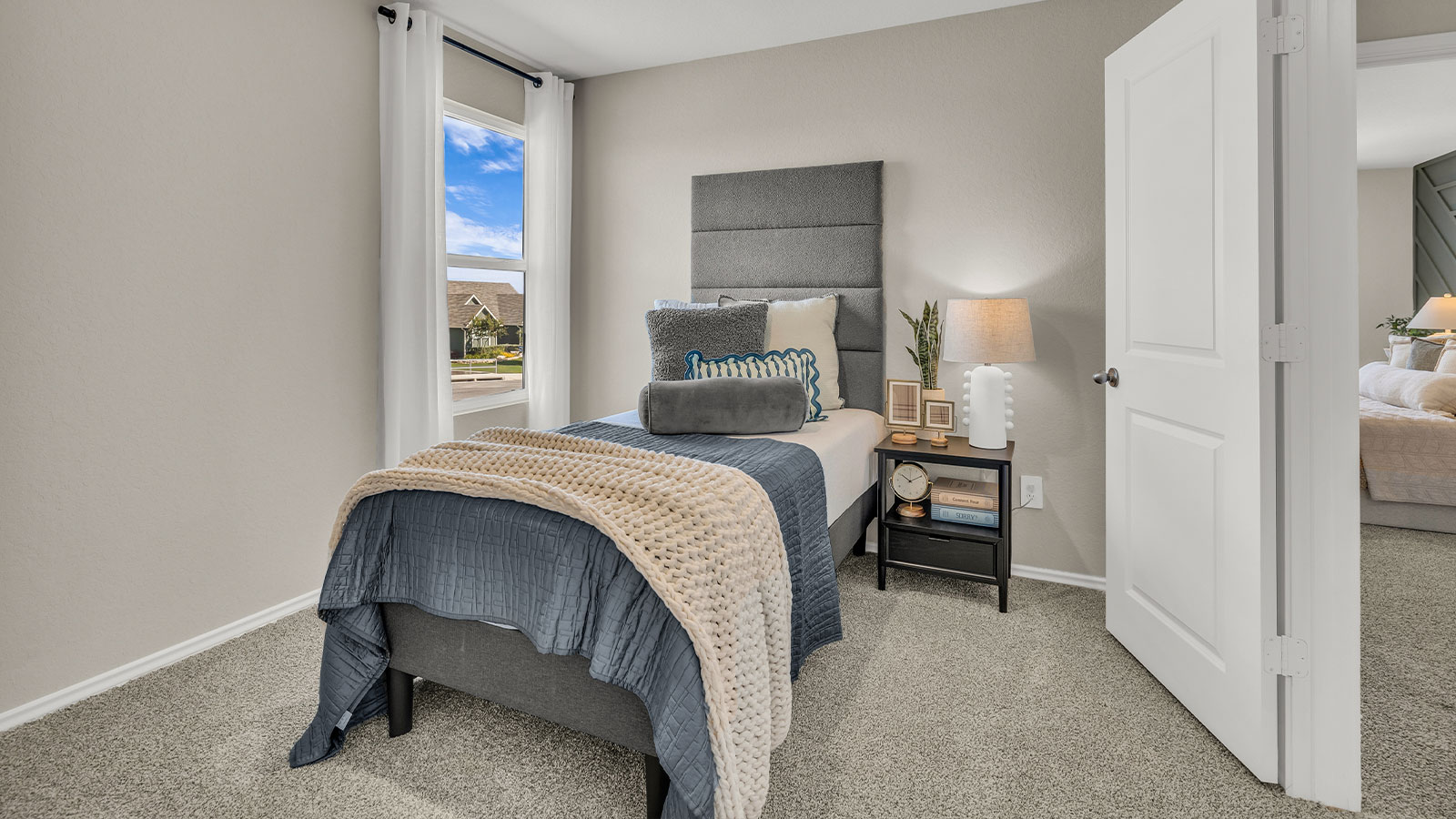Secondary bedroom with carpeting and one window.