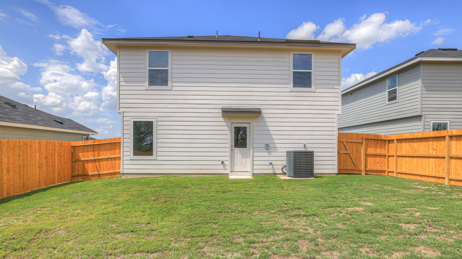 Backyard patio with sod and privacy fence.