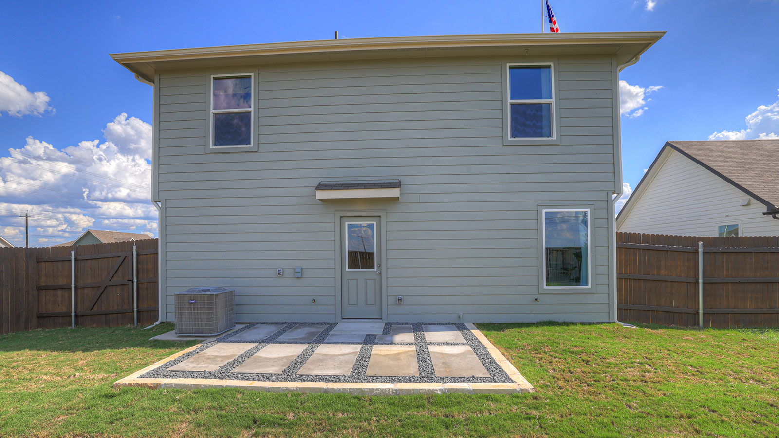 Backyard patio with sod and privacy fence.