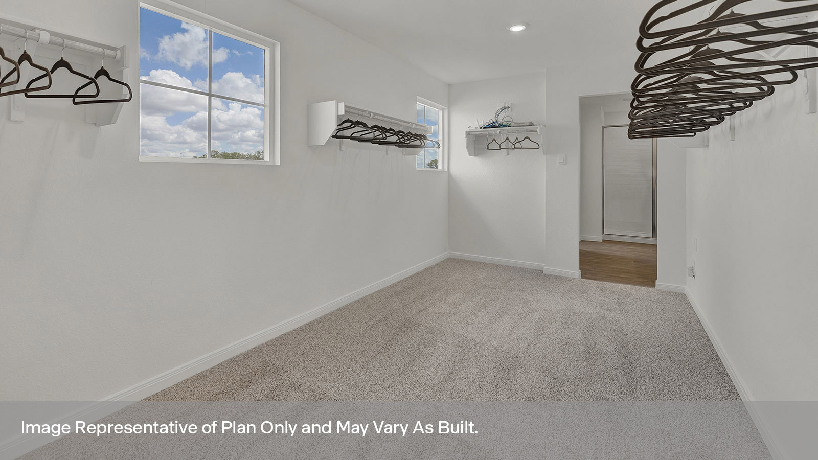 Main bedroom closet with carpeting and wooden shelving.