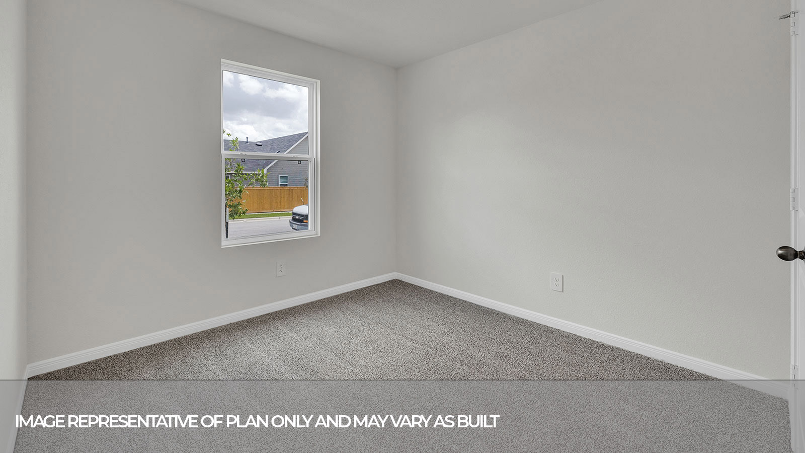 Bedroom with carpeting and one window looking into the side yard.