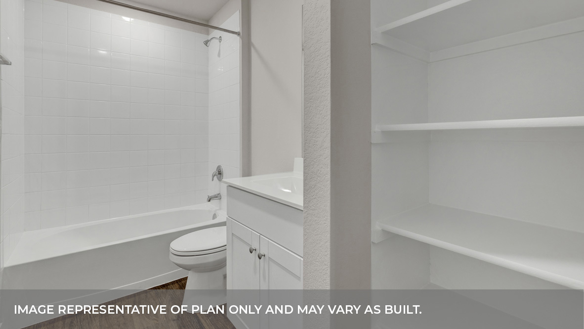 Hall bathroom with wooden shelving, toilet, and tub.