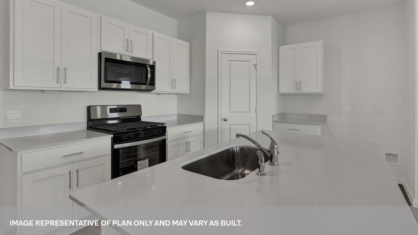 Kitchen island with quartz countertops and stainless steel sink.