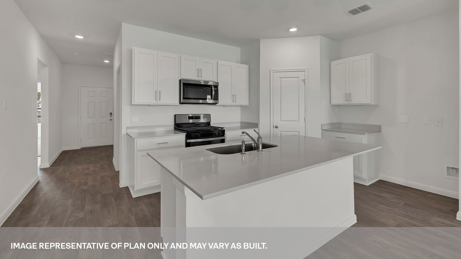 Kitchen island with quartz countertops and stainless-steel appliances.