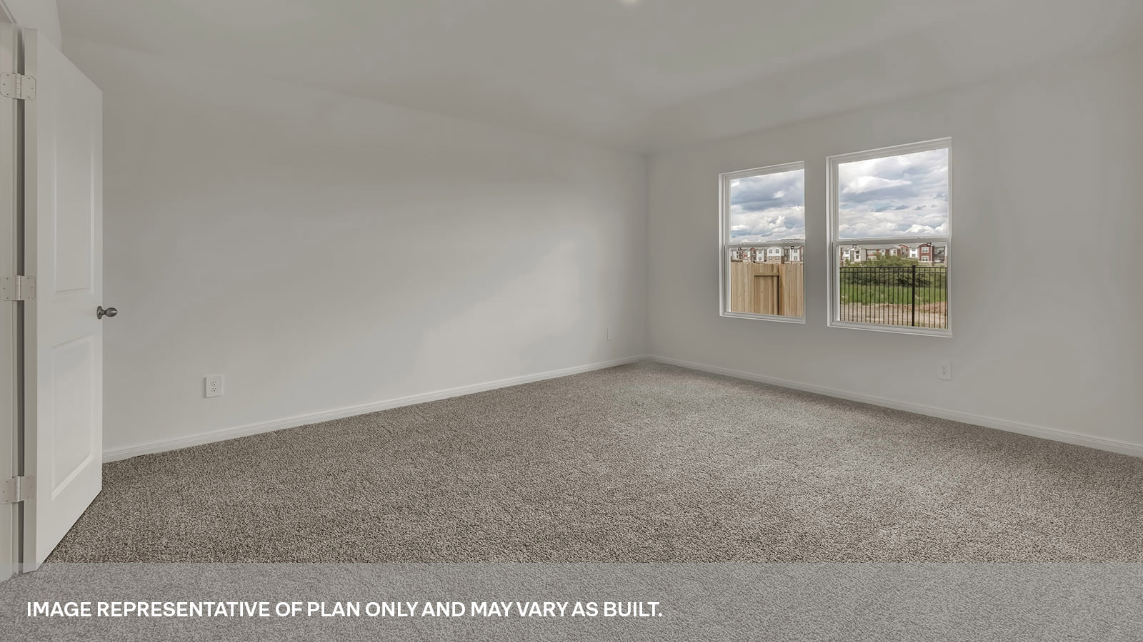 Main bedroom with carpeting and two windows.