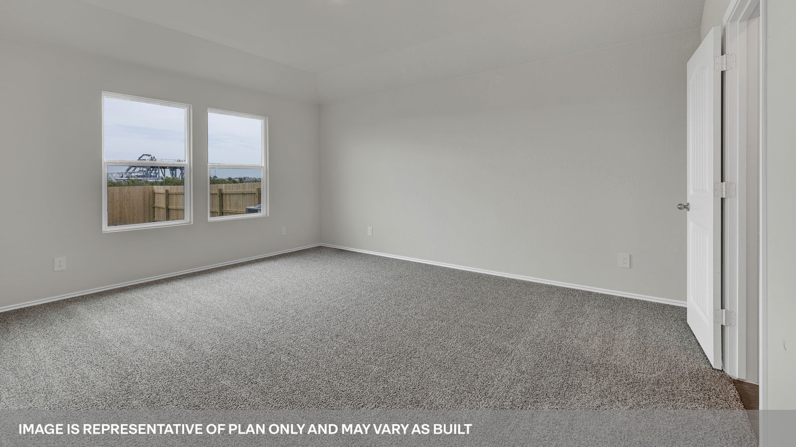 Main bedroom with carpeting and main bathroom entry