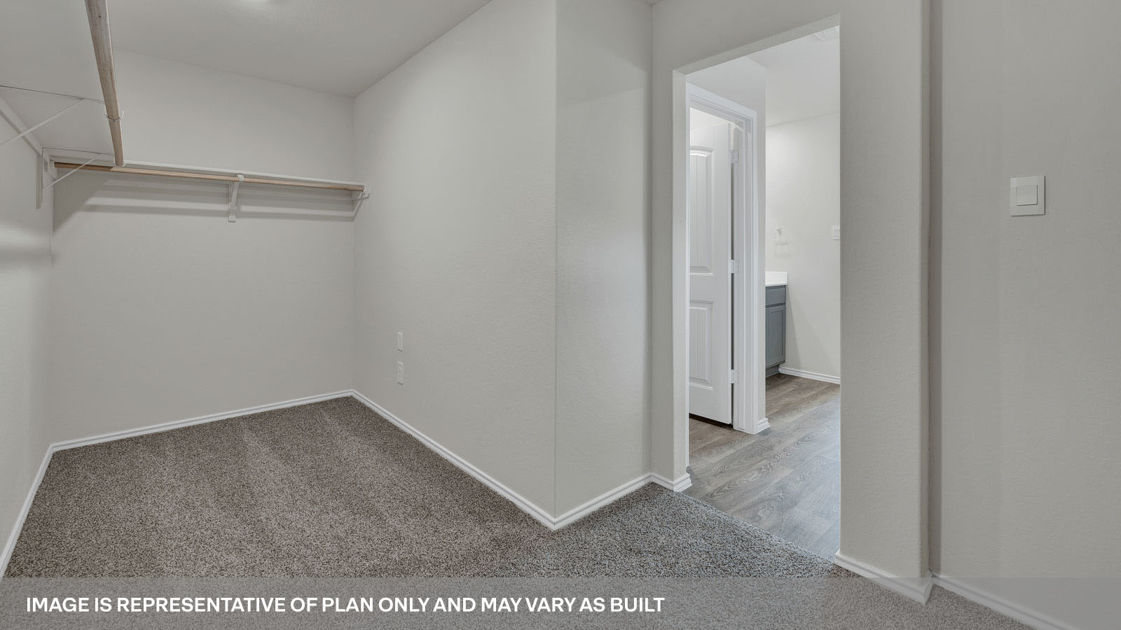 Main bedroom closet with carpeting and wooden shelving.