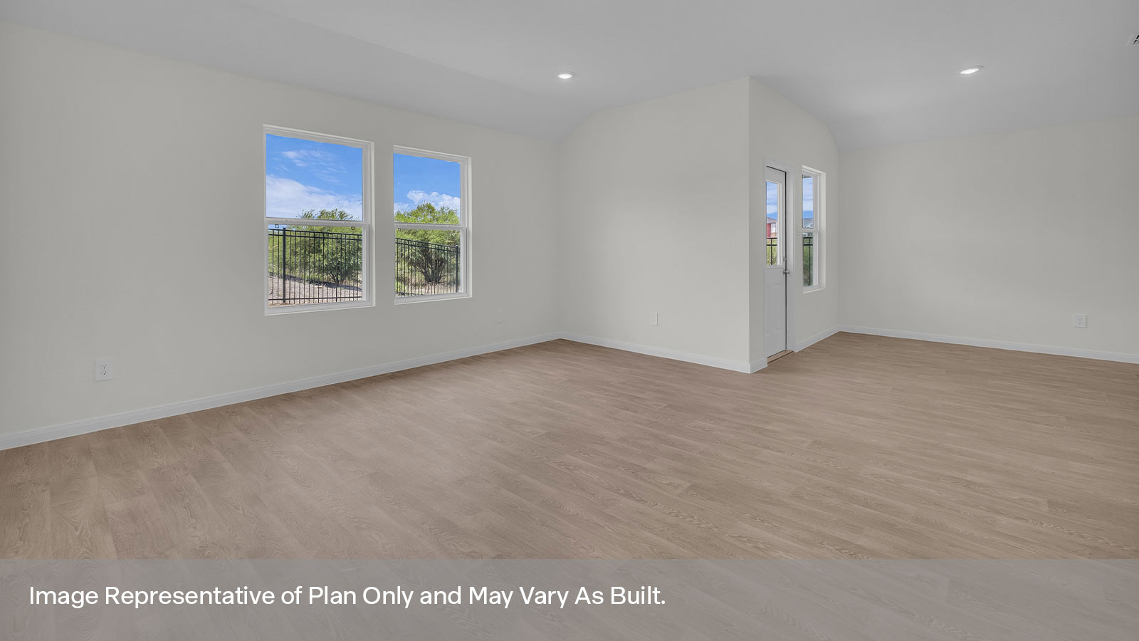 Dining room and living room with vinyl flooring, 3 windows, and a half lite exterior door.