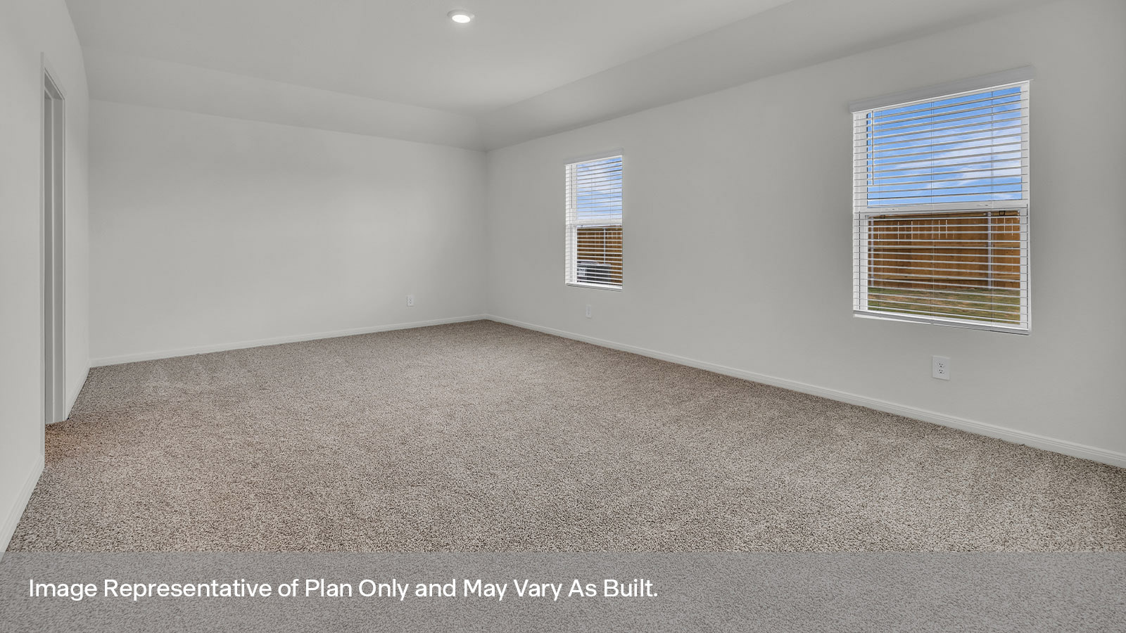 Main bedroom with carpeting and two windows.