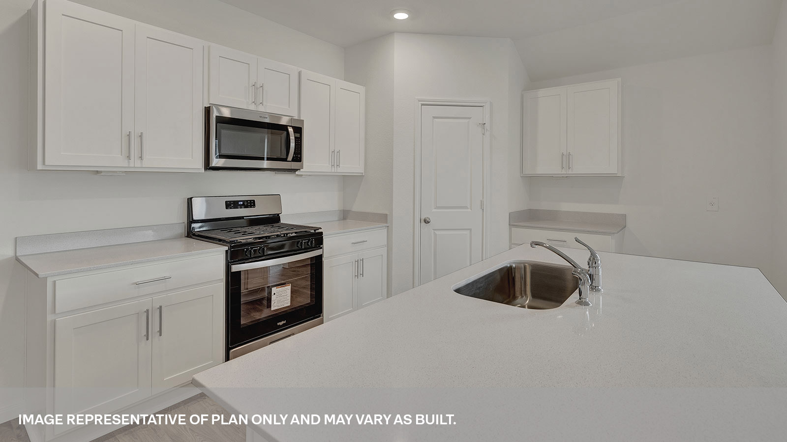 Kitchen island with quartz countertops and stainless steel appliances.