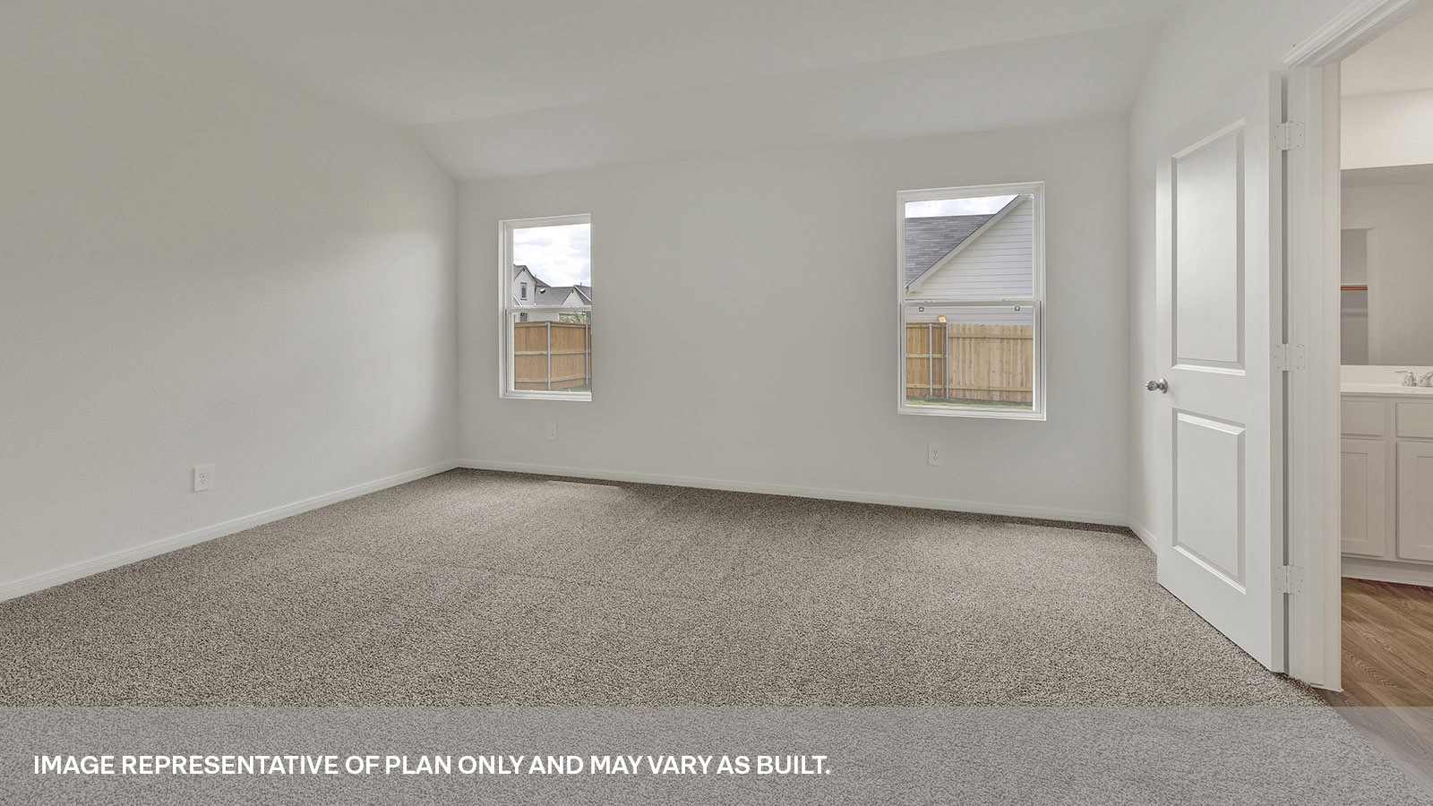 Main bedroom with carpeting and two windows.