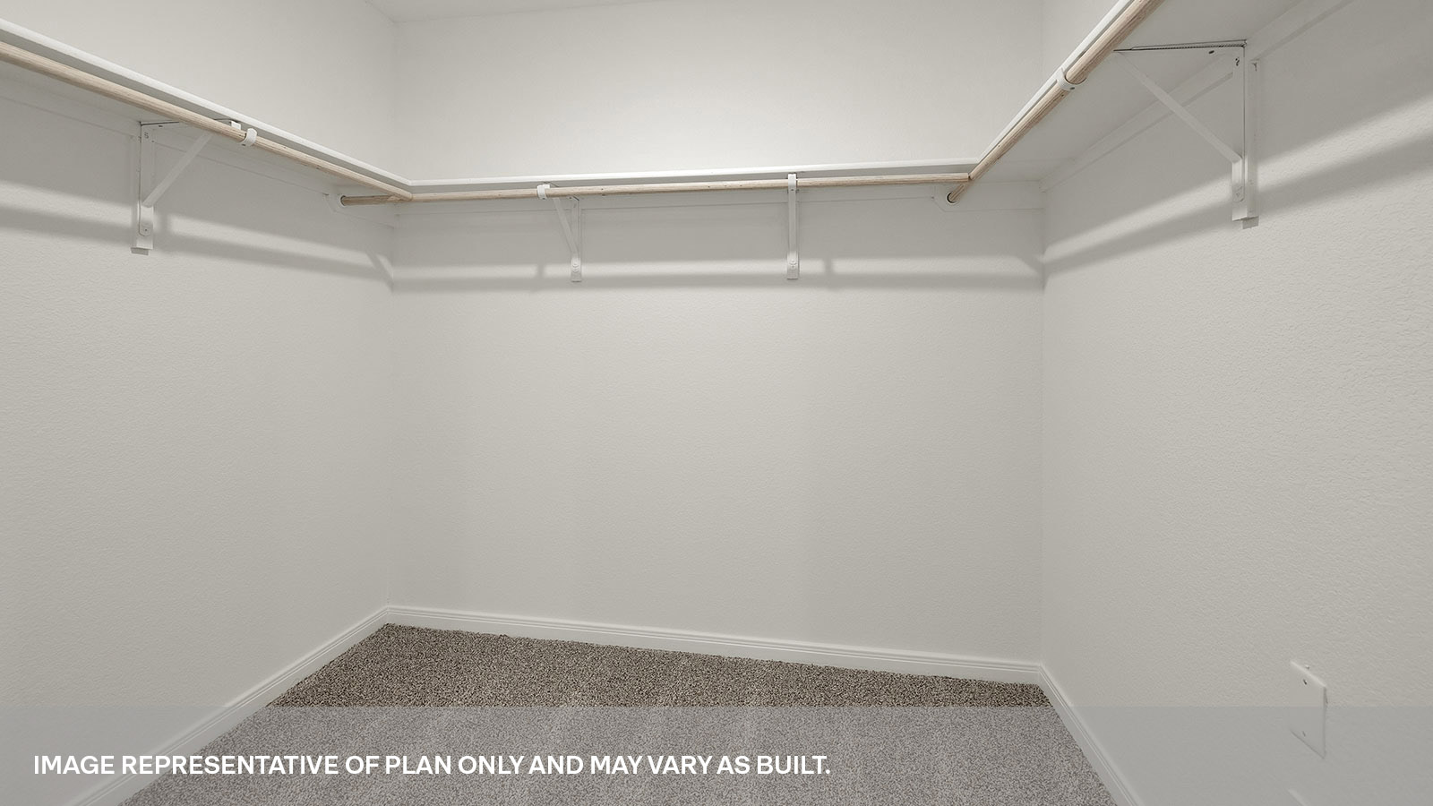 Main bedroom closet with carpeting and wooden shelving.