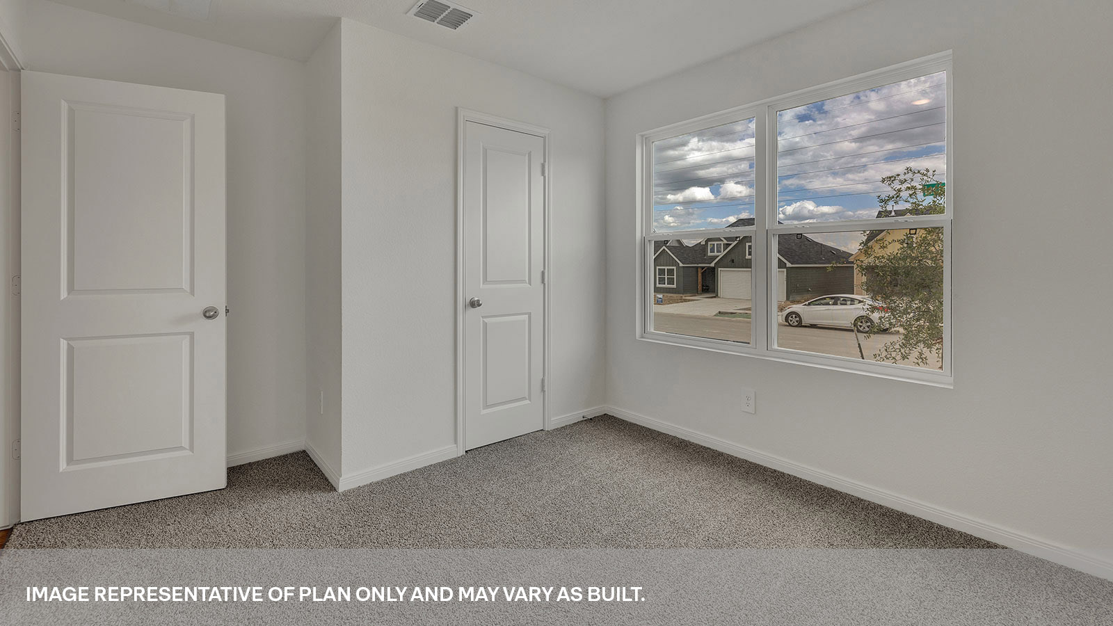Front bedroom with carpeting and two windows.