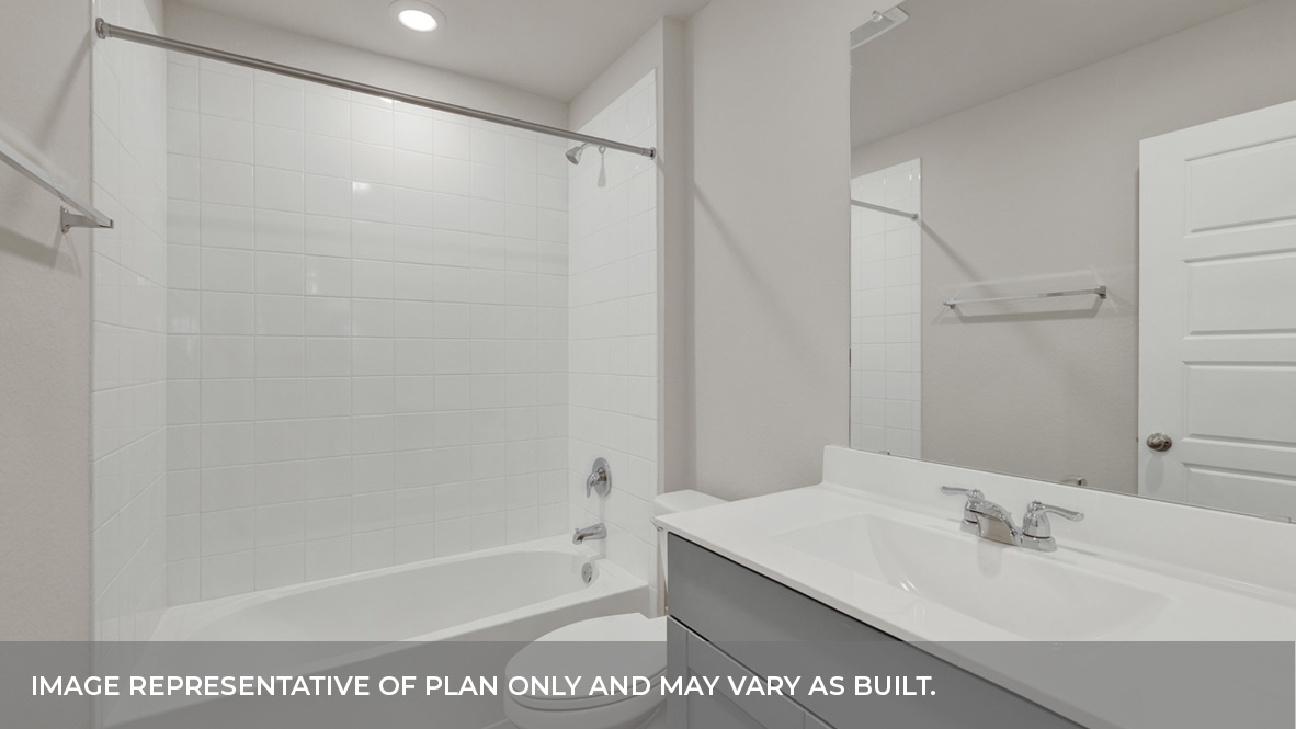 Hall bathroom with single-sink vanity with gray cabinet, toilet, and tub tile surround.
