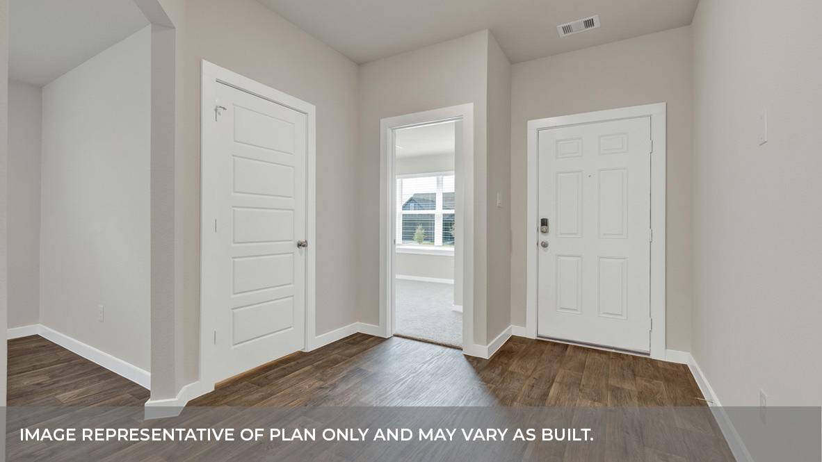 Entry hallway with vinyl flooring, front door, and front bedroom entrance.