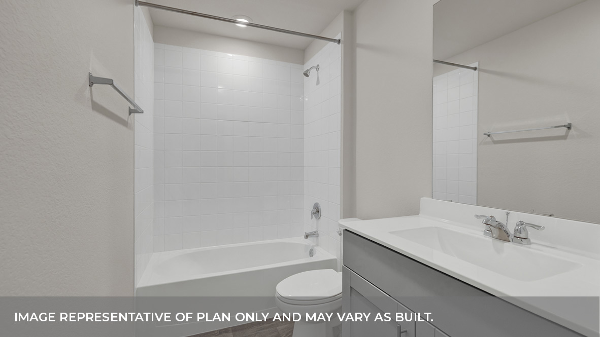 Hall bathroom with single sink vanity, toilet, and tub with tile surround.